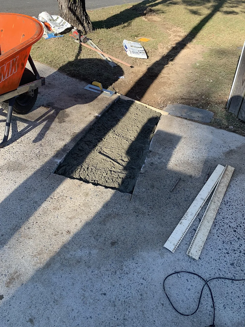 Same concrete path patch freshly poured and screeded